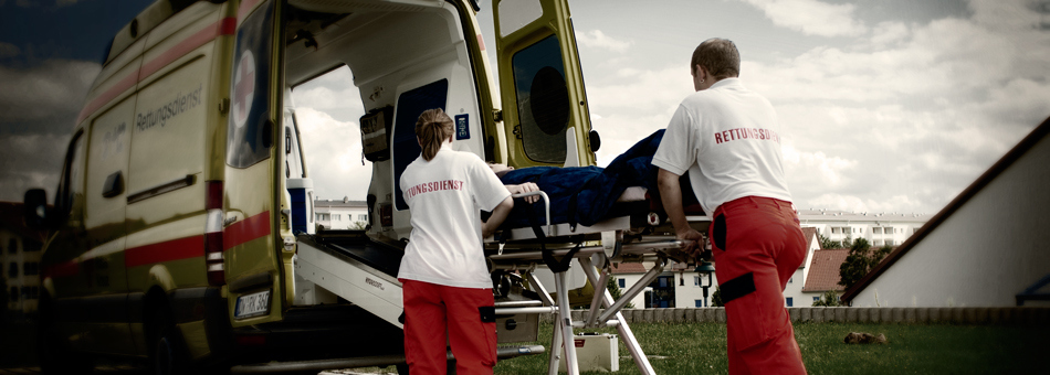 two ambulance service men at work